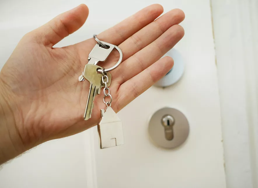 Main tenant clés avec porte-clés maison